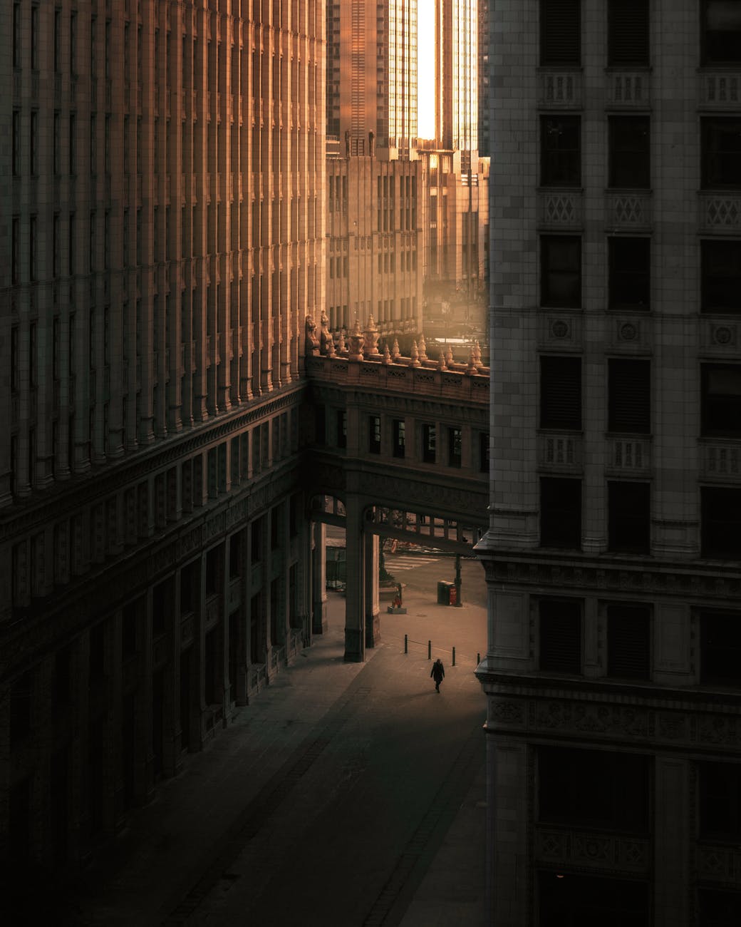 person walking on street between buildings