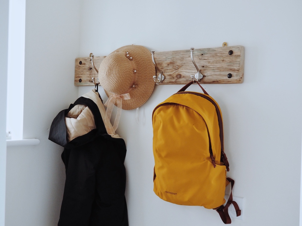 The Everything Backpack hung on a coat hook