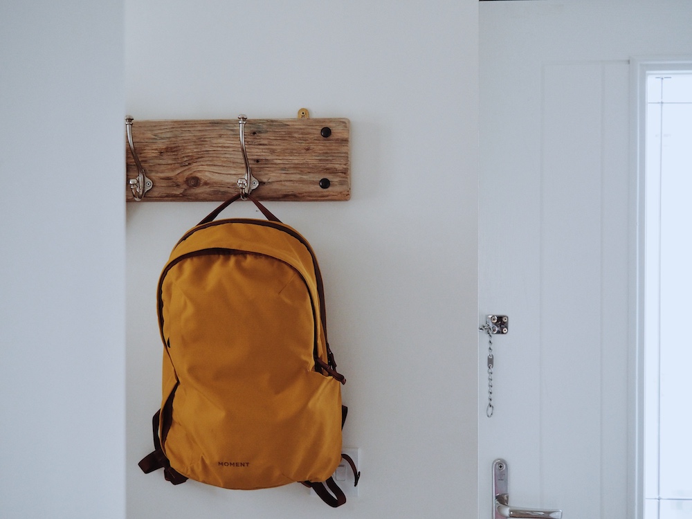 The Moment Everything Backpack hung on the coat hook