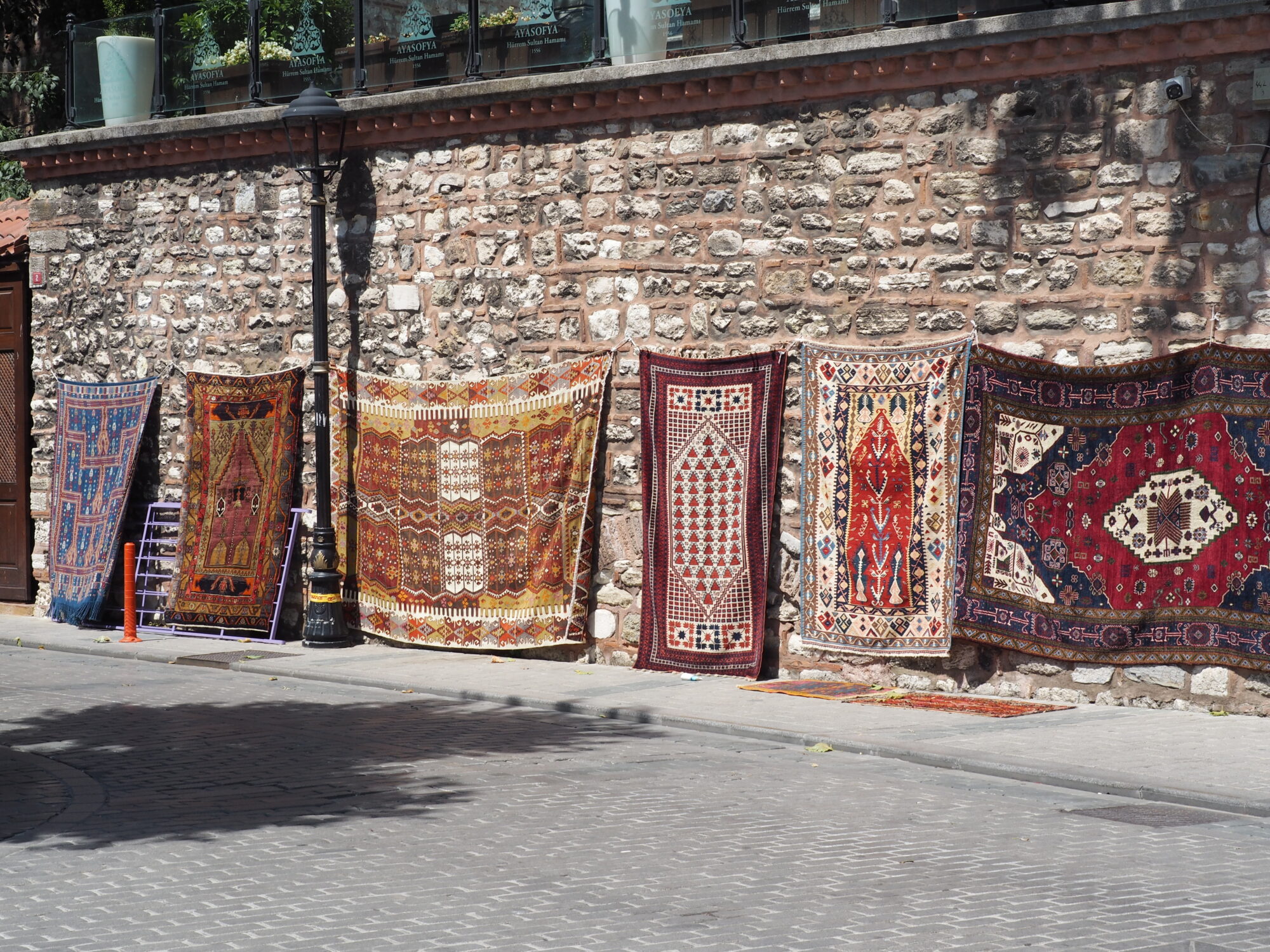 Traditional Turkish rugs for sale on a cobblestone street in Istanbul Turkey